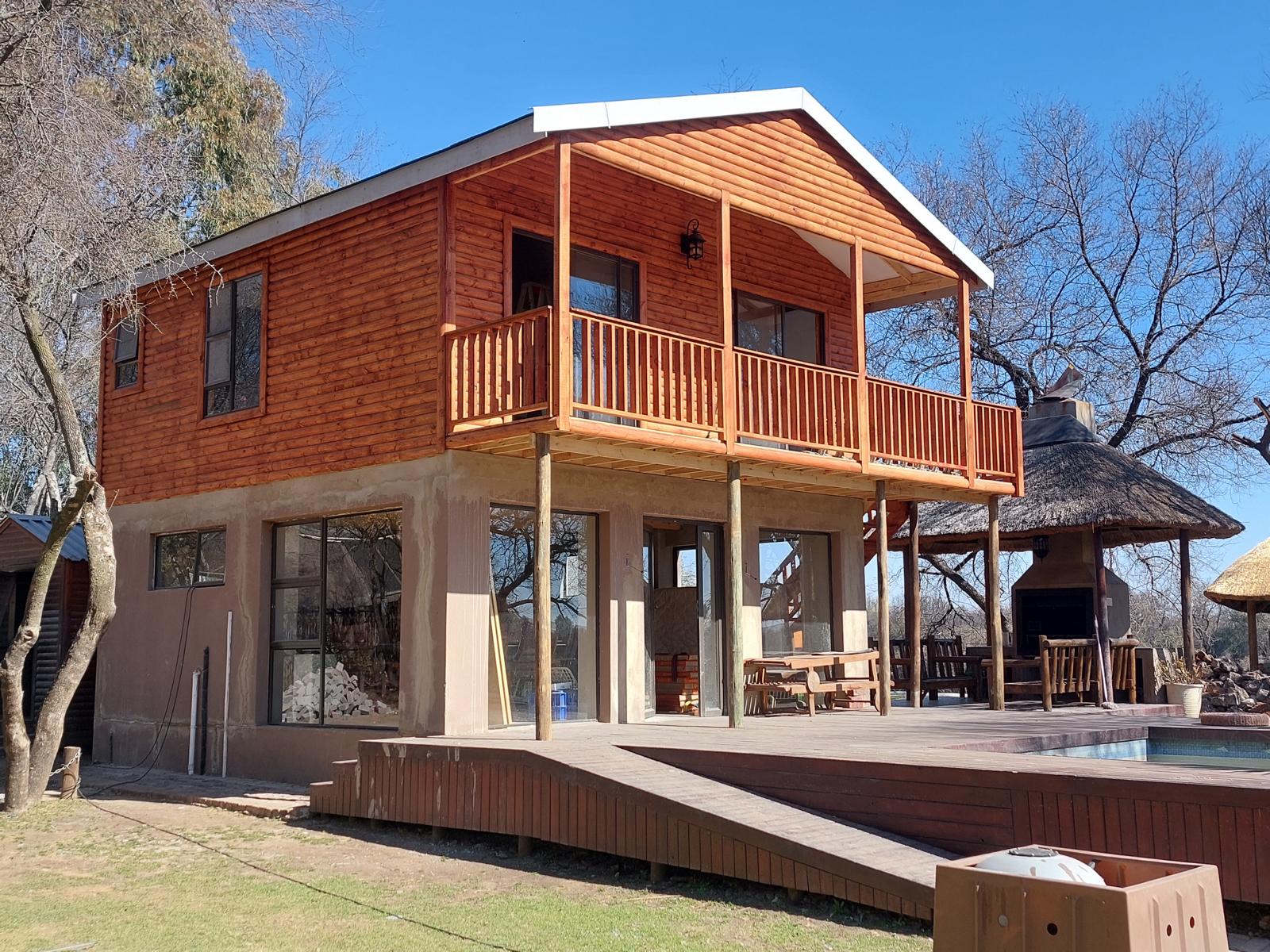 Double-storey timber home with a balcony and deck in Knysna