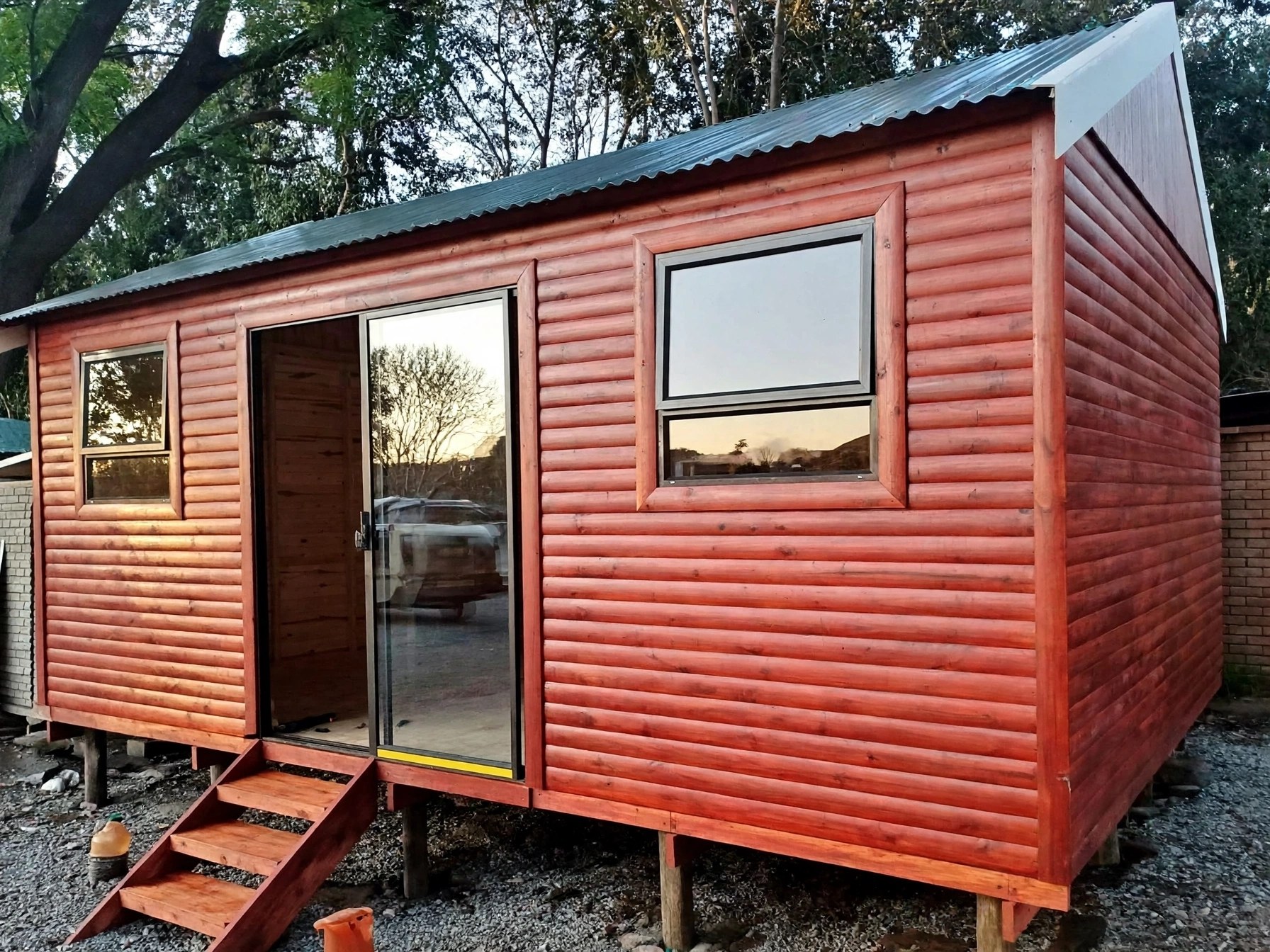 Compact timber building with glazed door and wooden steps