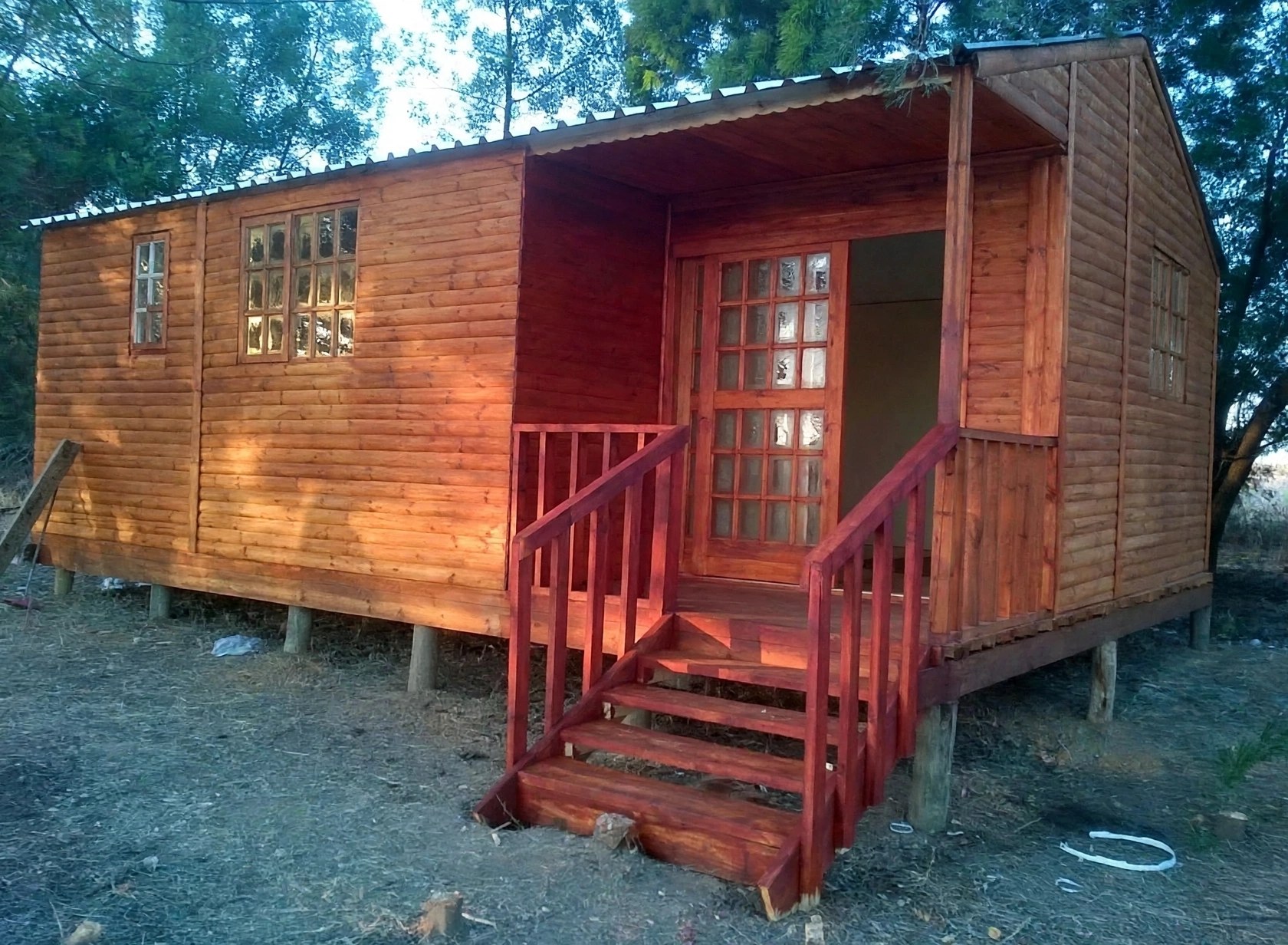 Timber cabin with covered entrance and red steps