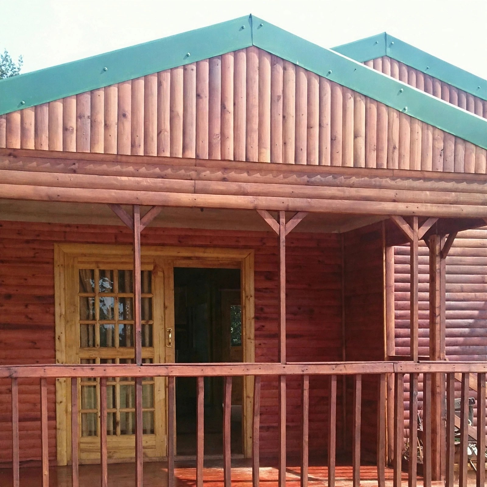 Timber home with green roof and front veranda