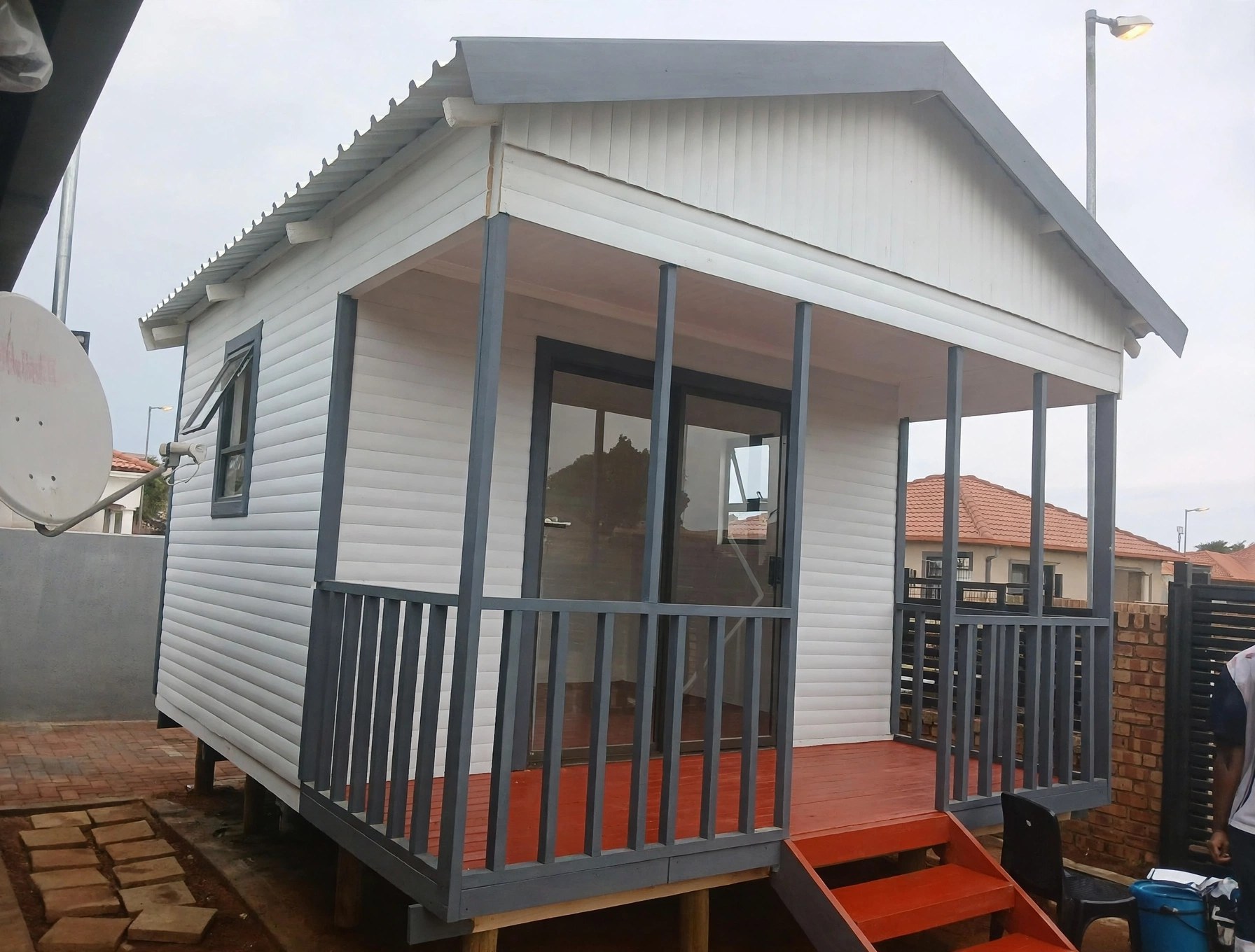 Grey home with red veranda railing