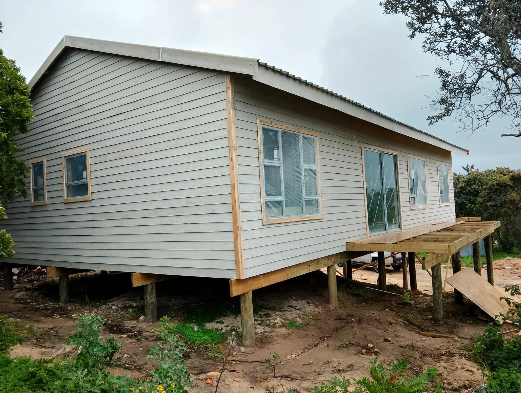 Raised light-coloured home with timber platform